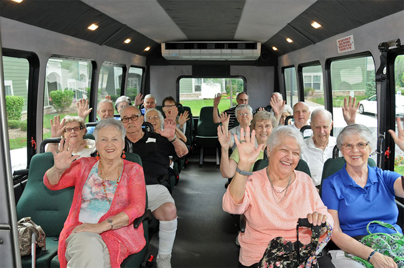 The Oaks at Bartlett | Group of seniors waving while on a bus