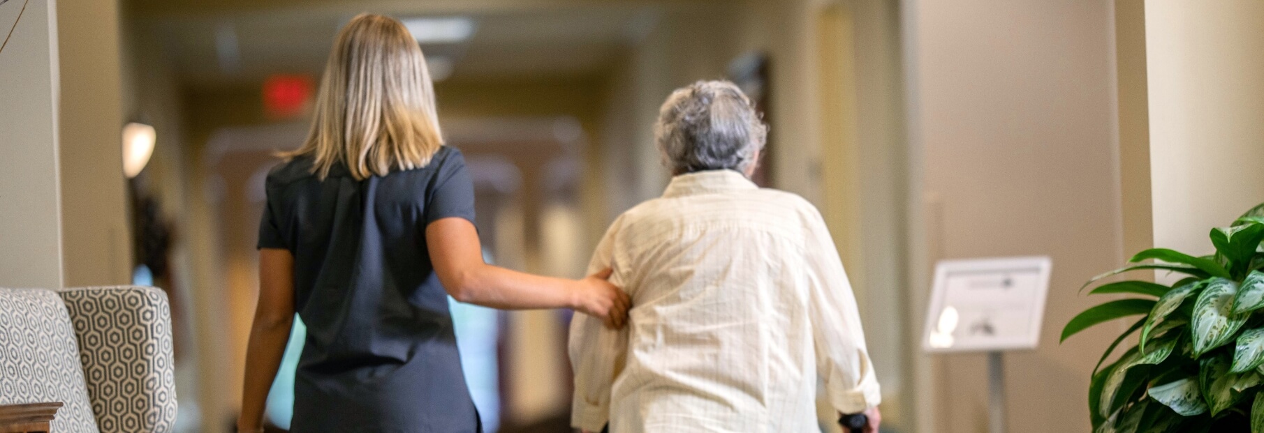 The Oaks at Bartlett | Senior and caregiver walking down the hall