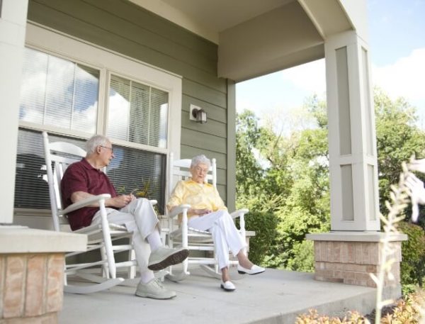 The Oaks at Bartlett | Two happy seniors sitting on the porch in rocking chairs